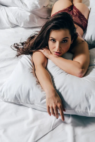 Sexy Bruna Donna Mutandine Rosse Sdraiato Sul Cuscino Casa — Foto Stock