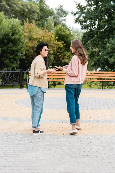 Happy Girls Sunglasses Smiling While Looking Each Other Talking Park — Stock Photo, Image