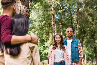 Afro-Amerikan erkek ve neşeli girrl arkadaşlarım parkta bakarak seçici odak