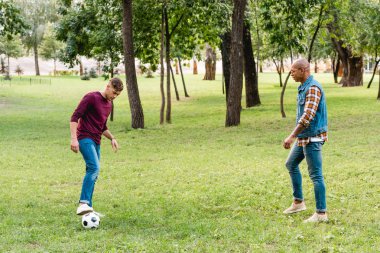 çok kültürlü arkadaşlar park yeşil çim futbol oynamak