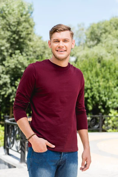 Feliz Joven Sonriendo Mientras Está Pie Con Mano Bolsillo — Foto de Stock