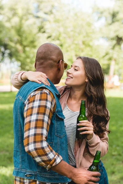 Gadis Ceria Berbisik Telinga African American Pacar Sambil Memegang Botol — Stok Foto