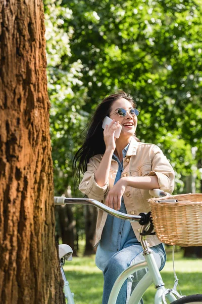 Χαρούμενο Κορίτσι Γυαλιά Ηλίου Μιλάμε Για Smartphone Κοντά Ποδήλατο Στο — Φωτογραφία Αρχείου