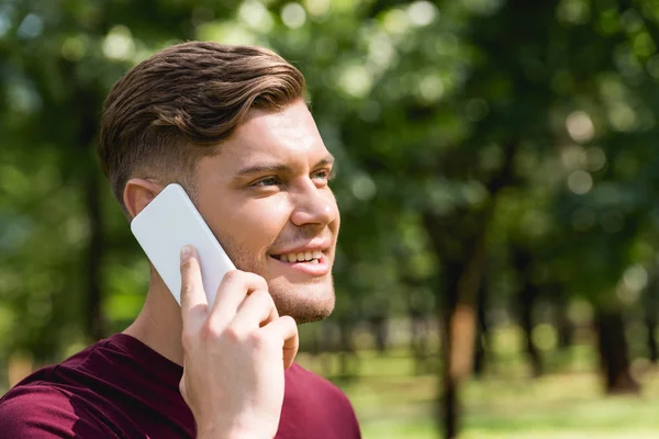 Веселый Молодой Человек Разговаривает Смартфоне Парке — стоковое фото