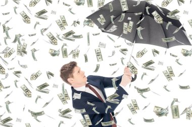 para yağmur altında şemsiye tutan takım elbiseli başarılı iş adamı