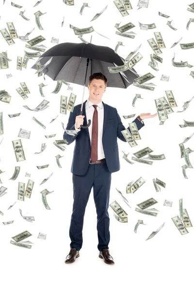傘はお金の雨の下で身振りで示すことスーツのビジネスマンを笑顔 — ストック写真