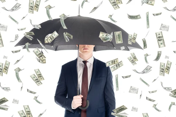 businessman in suit with obscure face and umbrella under money rain