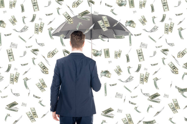 back view of businessman in suit holding umbrella under money rain on white background