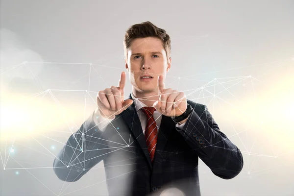 ネットワーク図の前で指で指しているスーツに自信を持っているビジネスマン — ストック写真