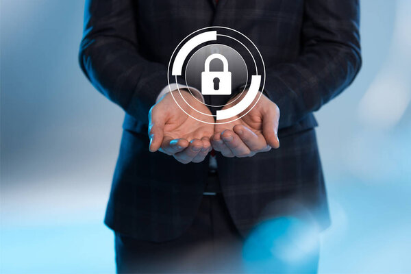 partial view of businessman with outstretched hands and internet security icon above on blue background