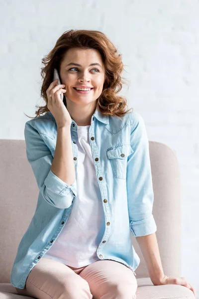 Happy Curly Woman Sitting Sofa Talking Smartphone Grey — Stock Photo, Image