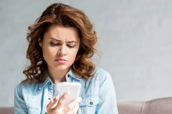 Smutny Kręcone Kobieta Koszula Patrząc Smartphone Szary — Zdjęcie stockowe