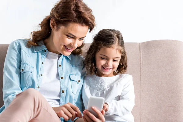 Iloinen Hymyilevä Äiti Tytär Istuu Sohvalla Käyttää Älypuhelinta Eristetty Valkoinen — kuvapankkivalokuva
