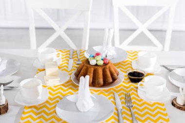 Boyalı yumurta ve çanak çömlek tablo Easter pastayla