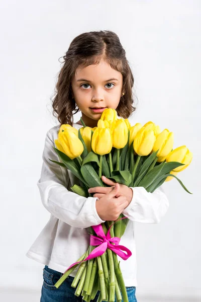 可爱的卷曲的孩子拿着郁金香花束白色的前面的看法 — 图库照片