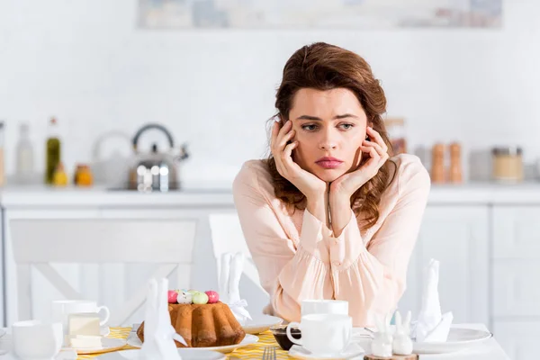 Vrouw Zitten Tabel Met Pasen Taart Stutten Gezicht Met Handen — Stockfoto