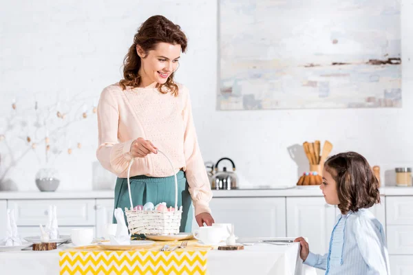 Smiling Woman Wicket Basket Looking Daughter While Serving Table Easter — Stock Photo, Image