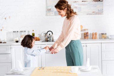 Anne ve küçük kızı mutfakta dururken peçete katlama