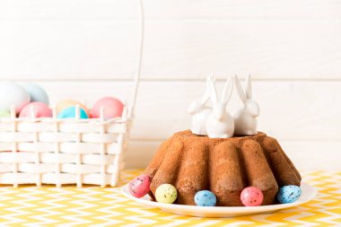 Paskalya kek seramik bunnies ve masada boyalı bıldırcın yumurtası 