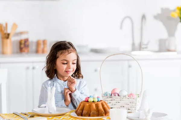 Lindo Niño Sentado Mesa Mirando Pastel Pascua Huevos Pintados Cocina — Foto de Stock