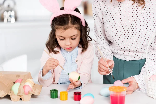 Miúdo Concentrado Orelhas Coelho Pintando Ovos Páscoa Com Mãe Cozinha — Fotografia de Stock