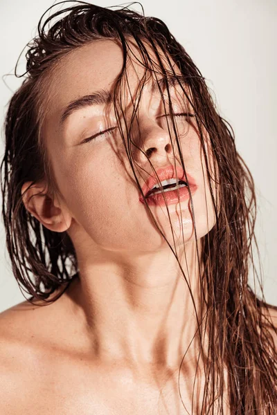 サンゴの唇と美しい魅惑的な若い女性 目閉じて濡れている髪はグレーに分離されたポーズ — ストック写真