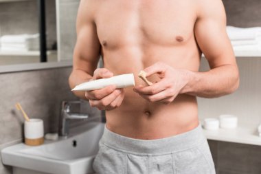 diş fırçası ve diş macunu elinde tutan adam görünümünü kırpılmış 