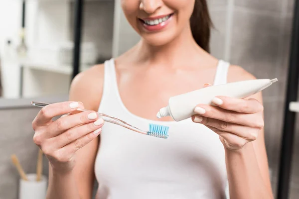 在浴室里使用牙膏时 愉快的妇女拿着牙刷的选择性焦点 — 图库照片