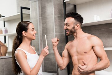 heyecanlı gömleksiz adam neşeli kız banyoda hamilelik testi holding, bakarken el hareketi 