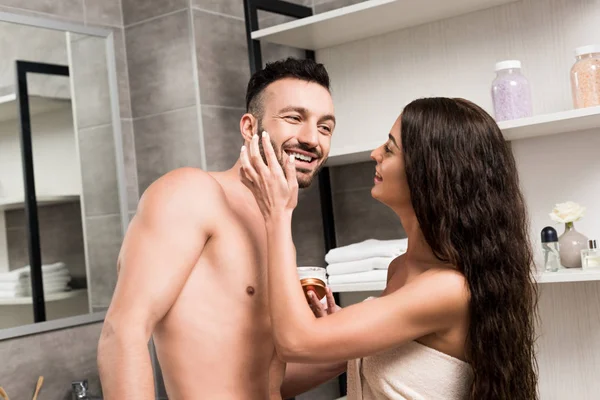 Happy Woman Applying Cosmetic Cream Cheek Happy Bearded Boyfriend — Stock Photo, Image