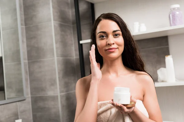 Attractive Woman Applying Face Cream Cheek While Standing Bathroom — Stock Photo, Image