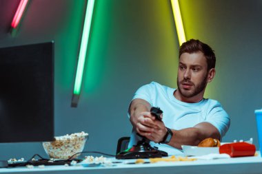 Joystick ile video oyunu oynarken yakışıklı ve iyi görünümlü siber sporcu
