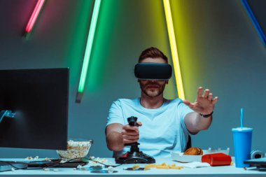 sanal gerçeklik kulaklık ve joystick kullanarak yakışıklı ve iyi görünümlü adam