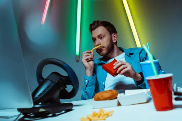 Bonito Bonito Homem Comendo Batatas Fritas Olhando Para Monitor Computador — Fotografia de Stock