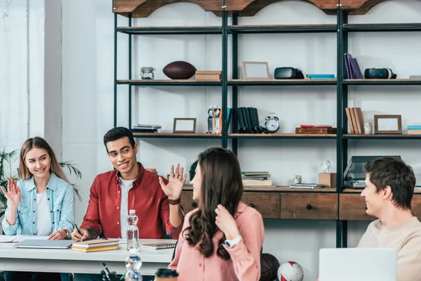 Smiling Multicultural Students Sitting Desk Waving Hands Friends — Stock Photo, Image