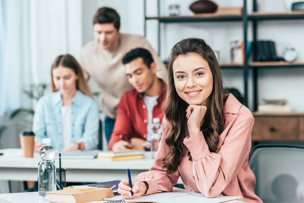 Estudiante Bonita Escribiendo Cuaderno Mirando Cámara — Foto de Stock