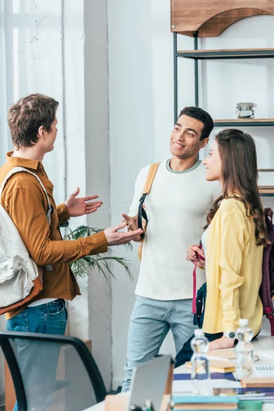 Tre Mångkulturella Glada Studenter Med Rygg Säckar Pratar Och Tittar — Stockfoto