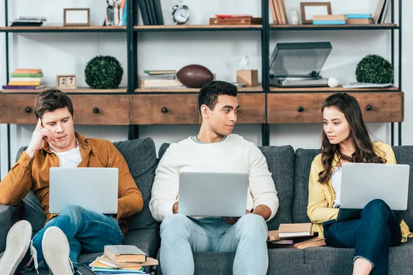 Tre Allegri Studenti Multietnici Seduti Sul Divano Laptop Uisng Casa — Foto Stock