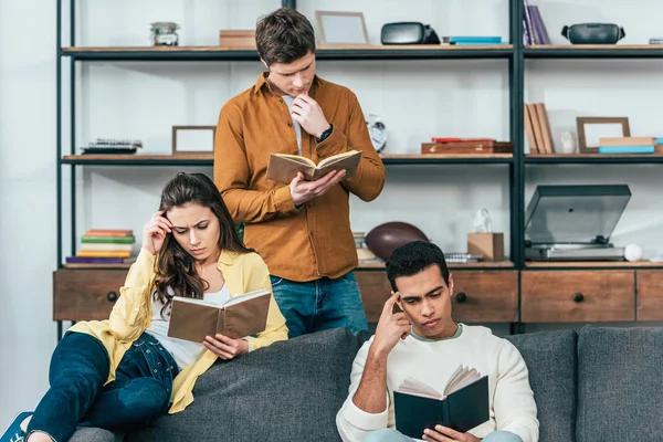 Tres Estudiantes Multiétnicos Sentados Sofá Leyendo Libros Salón — Foto de Stock