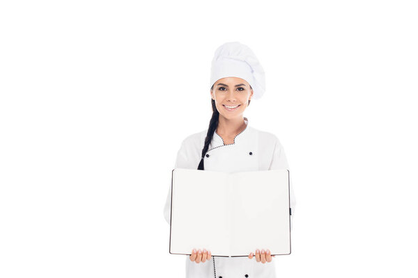 Smiling chef in hat holding open book isolated on white