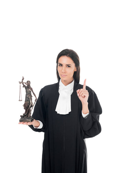 Judge in judicial robe holding themis figurine and showing idea gesture isolated on white