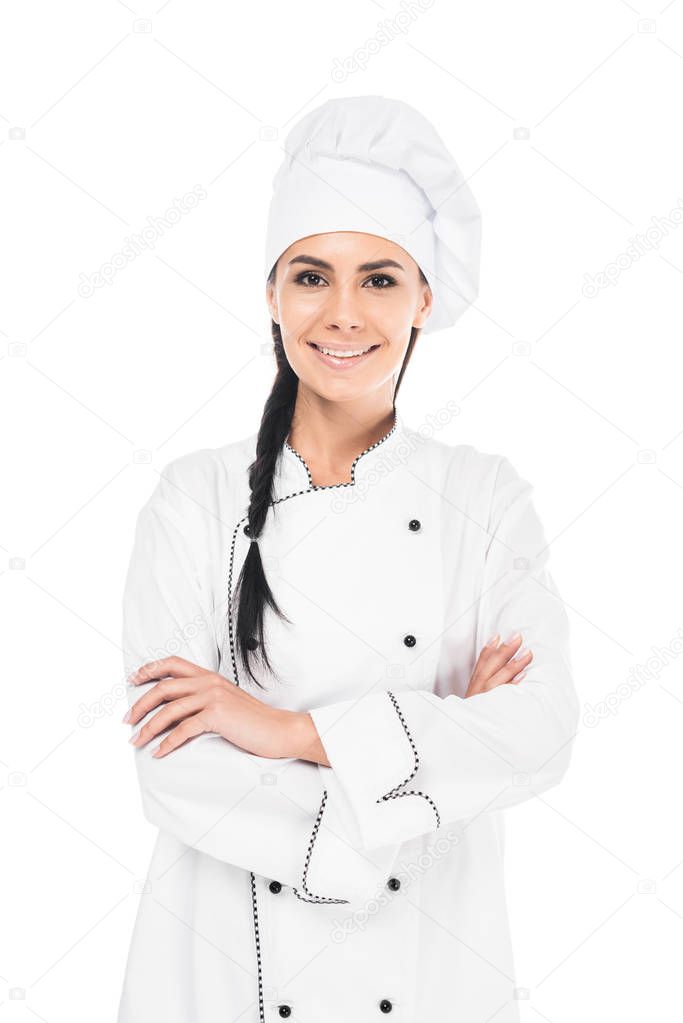 Smiling chef in uniform standing with crossed arms isolated on white