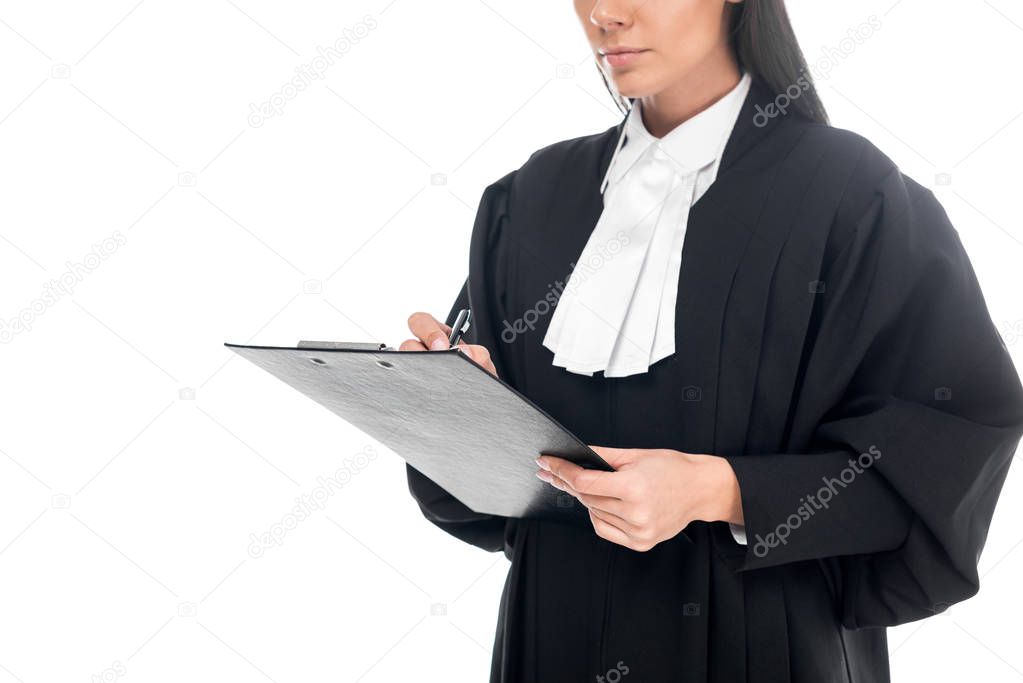 Cropped view of concentrated judge in judicial robe writing in clipboard isolated on white