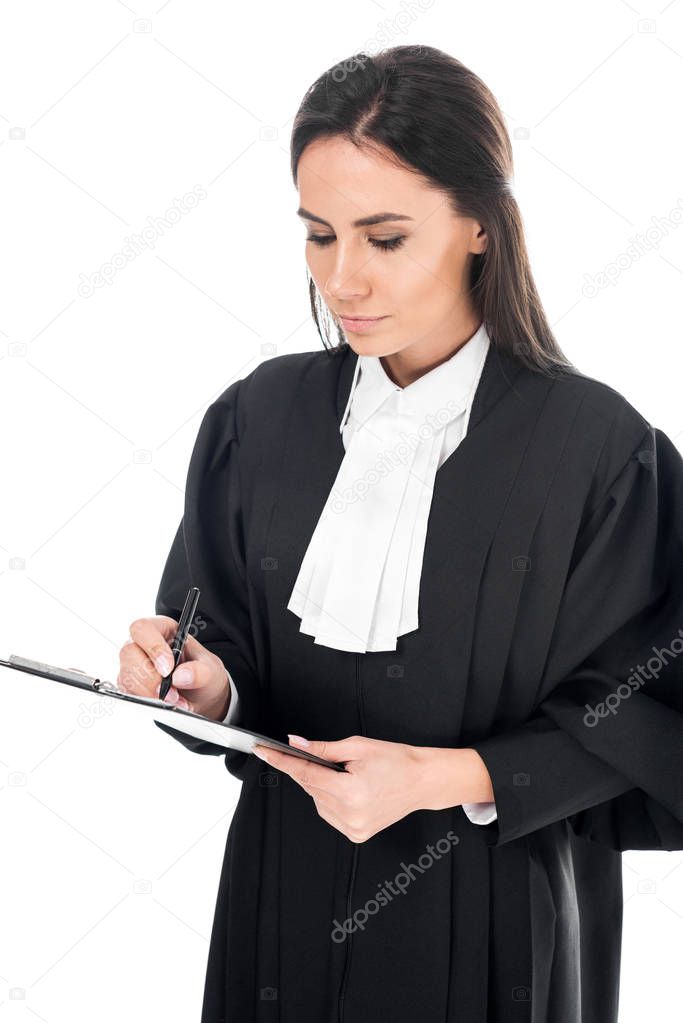 Concentrated judge in judicial robe writing in clipboard isolated on white