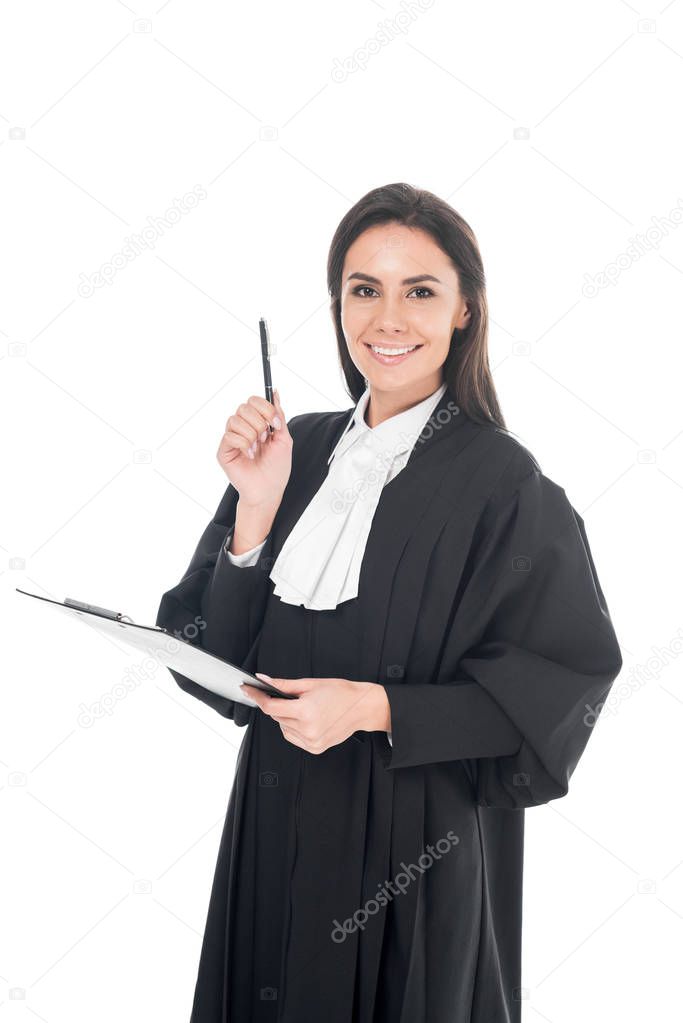 Smiling judge in judicial robe holding clipboard and pen isolated on white