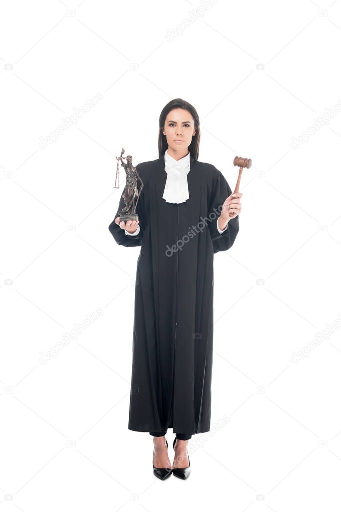 Full length view of judge in judicial robe holding gavel and themis figurine isolated on white