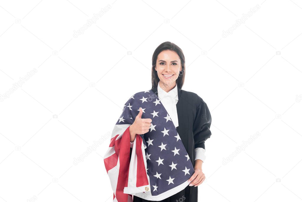 Smiling judge holding american flag and showing thumb up isolated on white