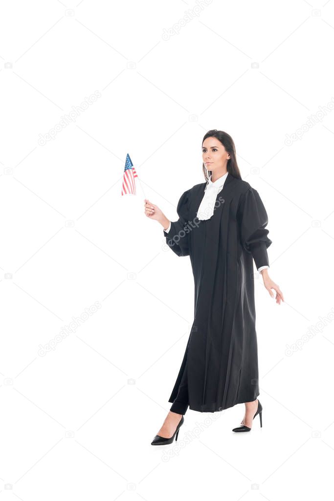 Judge in judicial robe holding american flag and walking isolated on white
