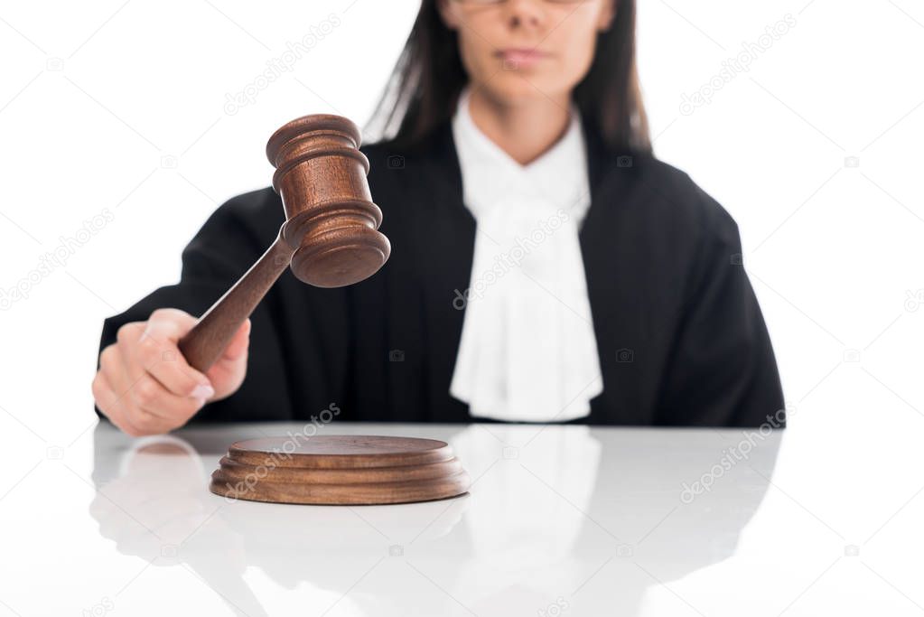 Partial view of judge in judicial robe holding gavel isolated on white