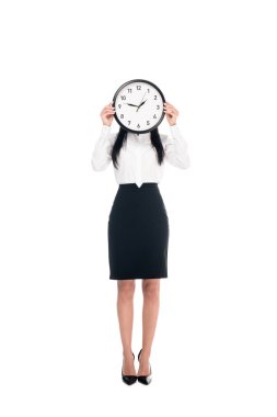 Full length view of brunette businesswoman in shirt holding clock isolated on white clipart